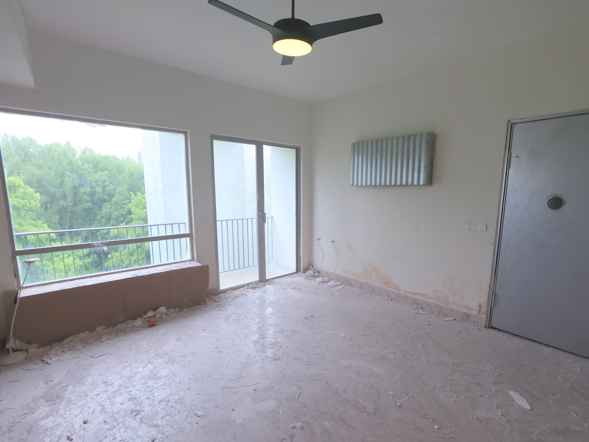 Room before cleaning — covered in fine construction dust and debris